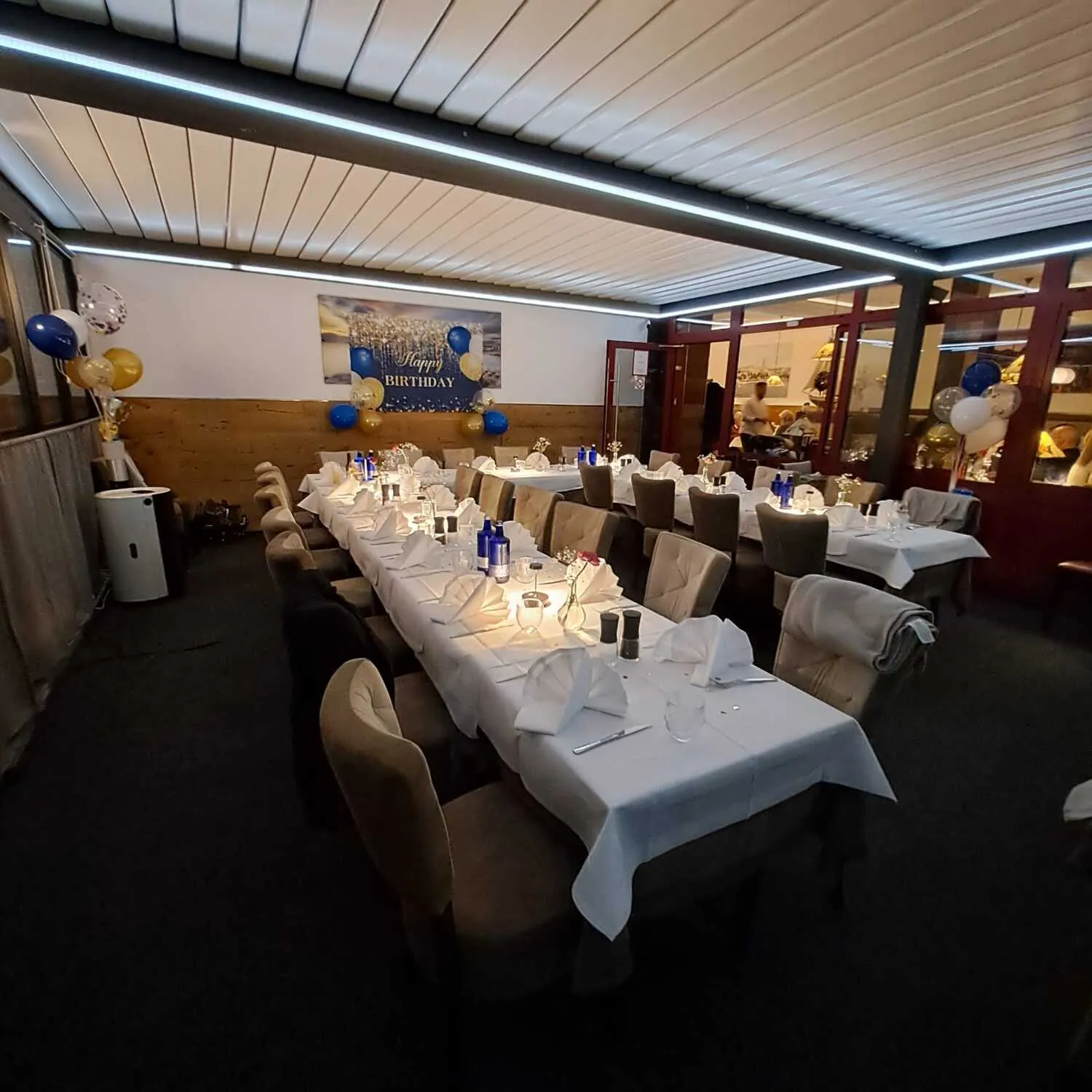 Überdachte Terrasse bei Nacht mit Happy-Birthday-Girlande